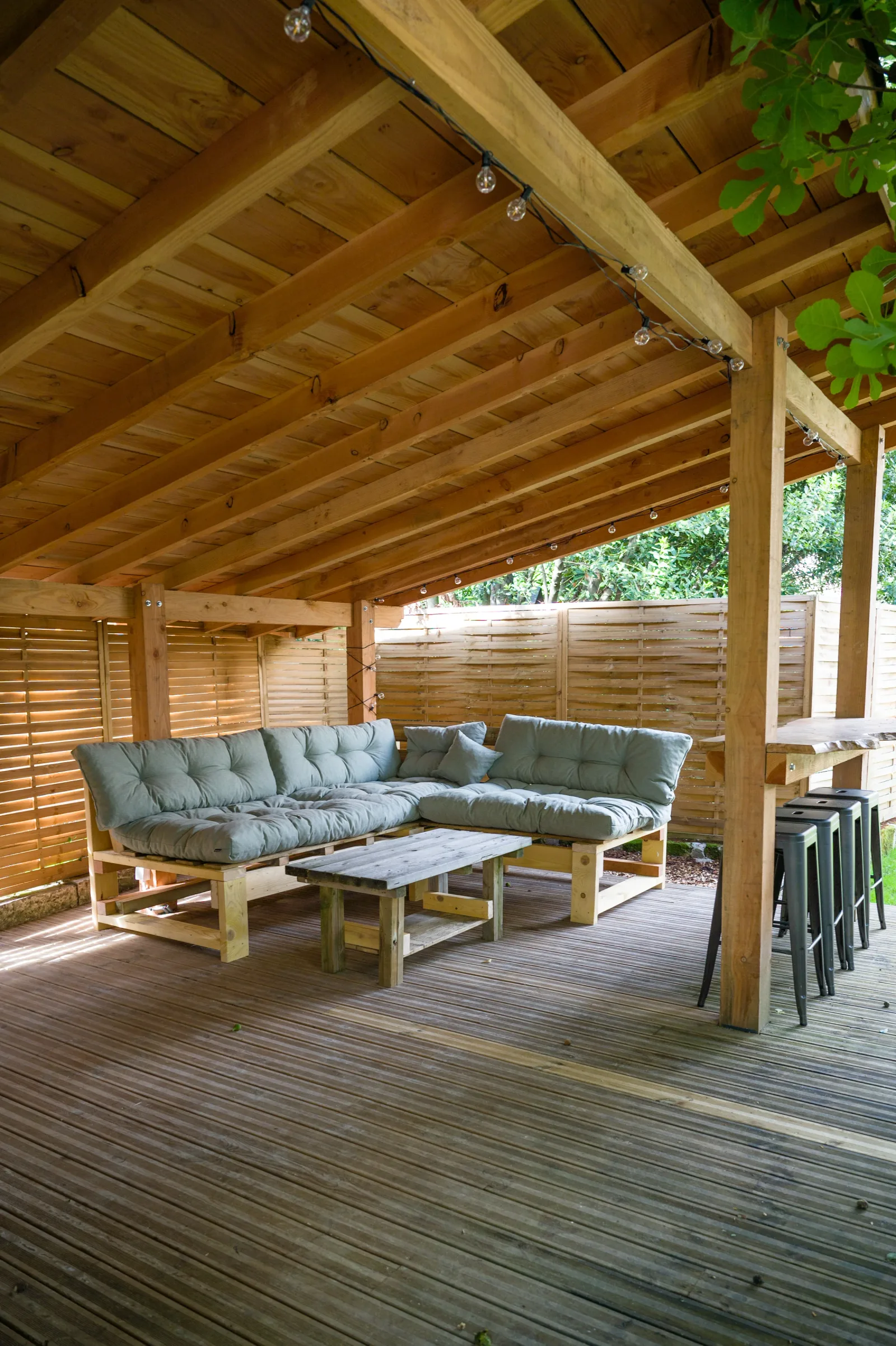 Pergola couverte côté studio, salon de jardin et bar extérieur